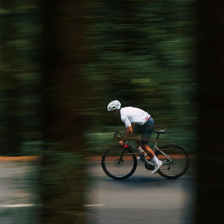 Cyclist riding at speed through a forest